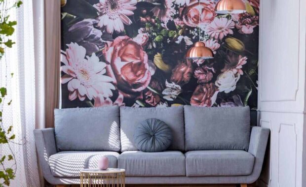 gray sofa by a floral print wall in the nook of a feminine living room interior