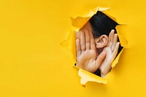 girl trying to hear from yellow wall