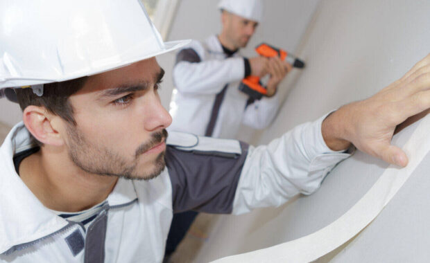painter worker protecting wall before painting at home improvement work