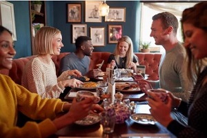 friends sitting down in restaurant with acoustic art panels