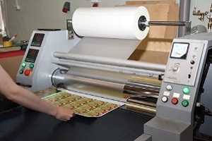 man applying lamination to print sheet