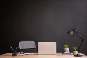 stylish workplace with modern laptop near dark wall