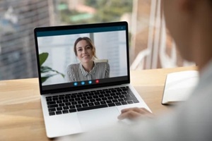 rear over shoulder view of man talk speak with smiling female colleagues on video online call on laptop