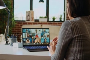 remote employee in cozy apartment talking with coworkers during teleconference meeting