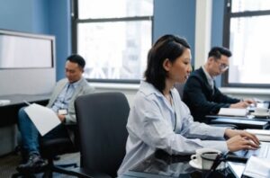 focused asian professionals working on laptops in a modern office environment