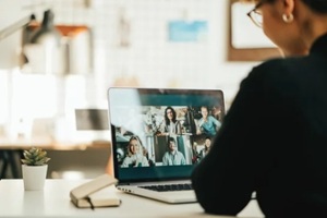 woman has video call with her team using laptop and camera
