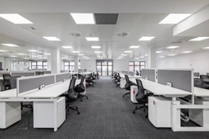 corporate open office in minimalist modern design in whites and greys, empty office workstations