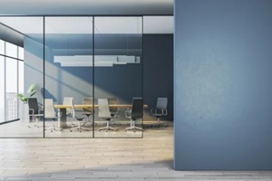 modern corporate meeting room behind glass walls with empty blue wall foreground as clean mockup space for design templates